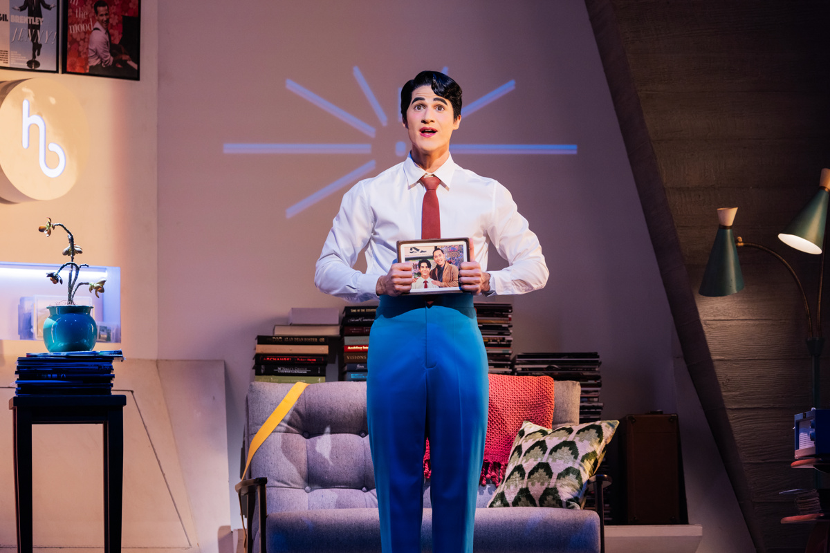 Oliver stands in the center of his apartment